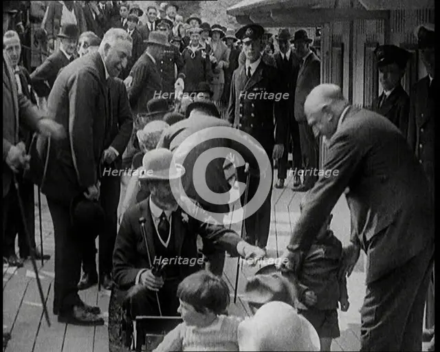 King George V of the United Kingdom Sitting On a Model Train With a Crowd of People Watching, 1924. Creator: British Pathe Ltd.
