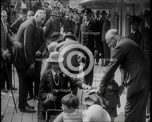 King George V of the United Kingdom Sitting On a Model Train With a Crowd of People Watching, 1924. Creator: British Pathe Ltd.