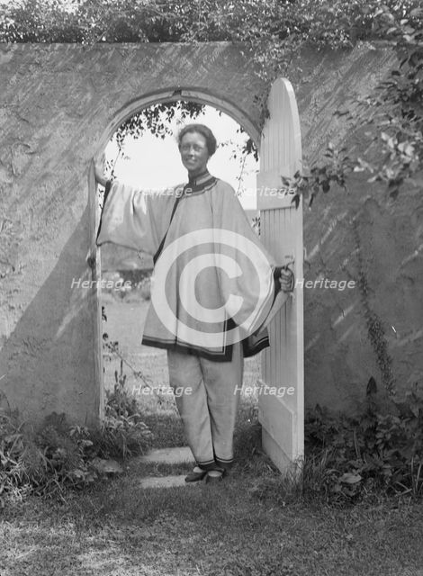 King, Hamilton, Mrs., standing in a garden door, 1932 Creator: Arnold Genthe.