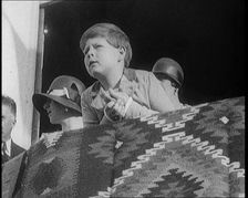 King Michael of Romania Leans Over a Balcony. Behind Him are Two Female Civilians, 1924. Creator: British Pathe Ltd