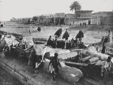 Kut-el-Amara avant les evenements actuels : chargement d'un chaland sur la rive du Tigre 1916. Creator: Unknown