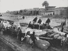 Kut-el-Amara avant les evenements actuels : chargement d'un chaland sur la rive du Tigre 1916. Creator: Unknown