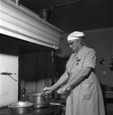 Housewife at the fireplace, Abonas, Sweden, 1956. Creator: Unknown