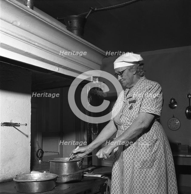 Housewife at the fireplace, Abonas, Sweden, 1956.
 Creator: Unknown.