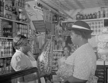 Housewife bargaining in the store owned by Mr. J. Benjamin, Washington, D.C., 1942. Creator: Gordon Parks