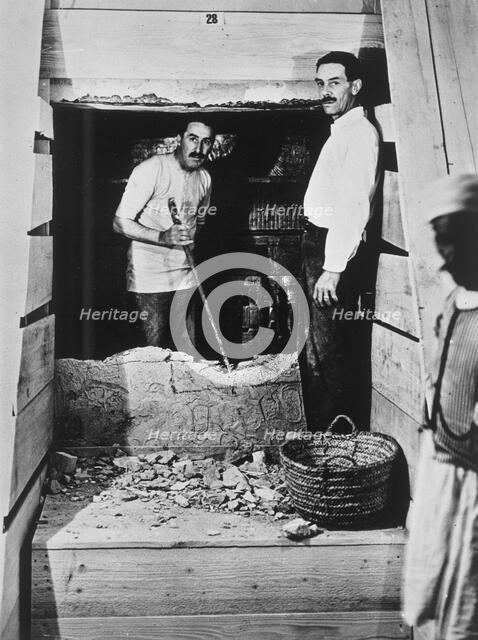 Howard Carter and a colleague excavating a tomb in the Valley of the Kings, Egypt, 1922. Artist: Harry Burton