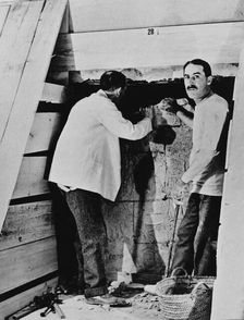 Howard Carter and a colleague excavating a tomb in the Valley of the Kings, Egypt, 1922. Artist: Harry Burton