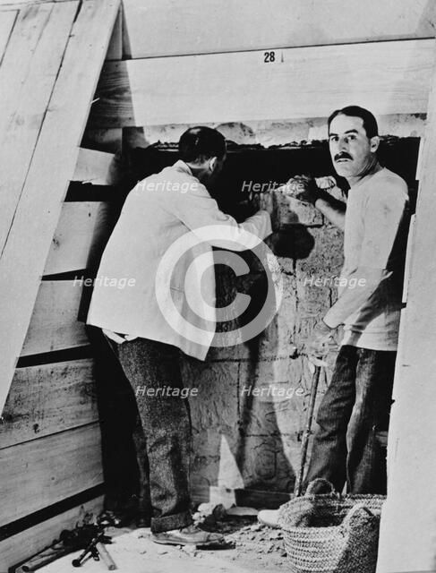Howard Carter and a colleague excavating a tomb in the Valley of the Kings, Egypt, 1922. Artist: Harry Burton
