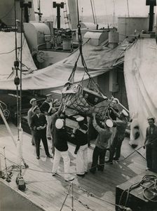 Hoisting a case from the deck of H.M.S. Suffolk at Portsmouth, July 1935. Creator: Topical Press Agency