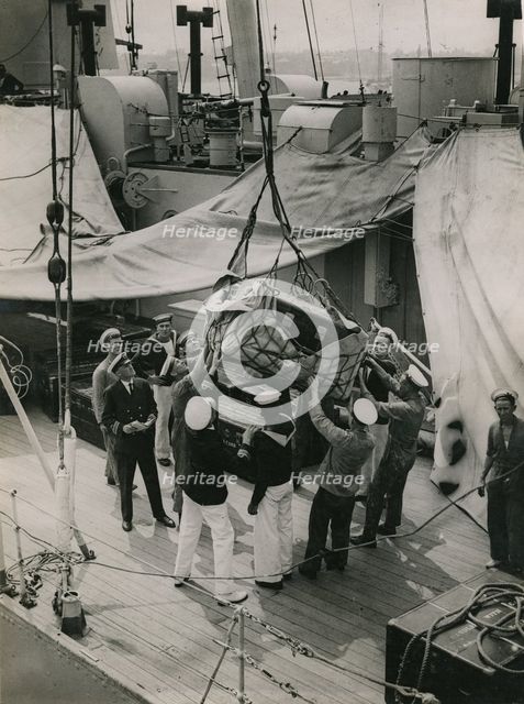 Hoisting a case from the deck of  H.M.S. Suffolk at Portsmouth, July 1935.  Creator: Topical Press Agency.