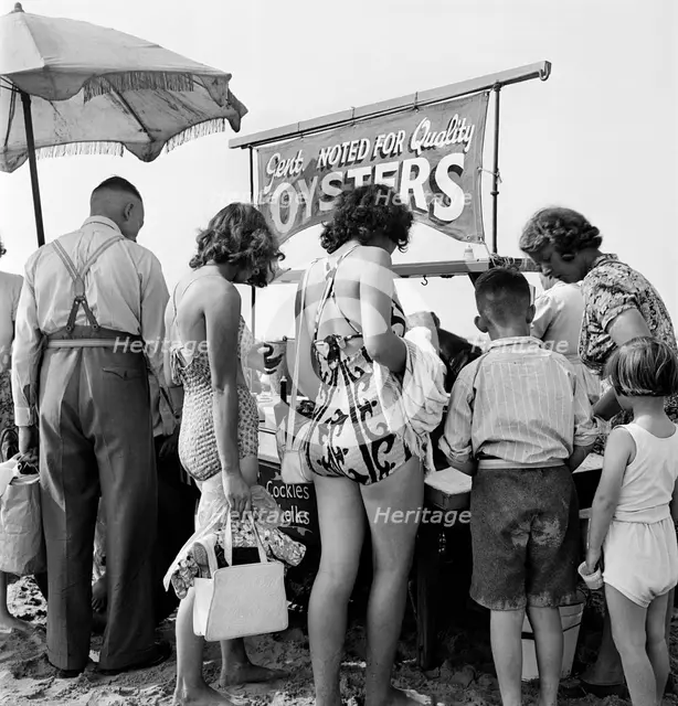 Holidaymakers around a seafood stall, Blackpool Beach, c1946-1955. Artist: John Gay