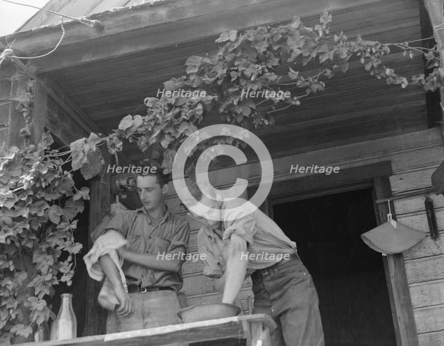 Hop farmer's sons, washing for noon meal on back porch, Independence, Polk County, Oregon, 1939. Creator: Dorothea Lange.