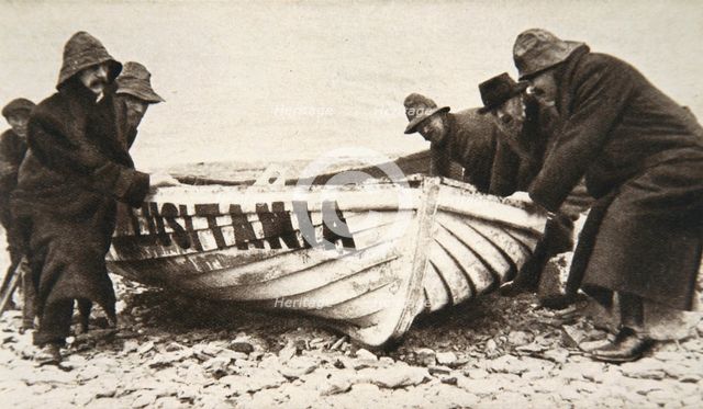 Hauling one of the 'Lusitania's' lifeboats onto the beach, Ireland, 8 May 1915.  Creator: Clarke & Hyde.