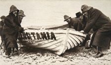 Hauling one of the Lusitania's lifeboats onto the beach, Ireland, 8 May 1915. Creator: Clarke & Hyde