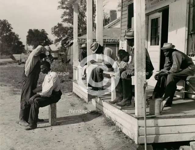 Haircutting in Front of General Store and Post Office on Marcella Plantation, Mileston, M..., 1939. Creator: Marion Post Wolcott.