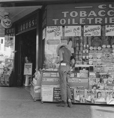 Half-grown farm boy on main drugstore corner in town, Medford, Oregon, 1939. Creator: Dorothea Lange