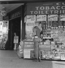Half-grown farm boy on main drugstore corner in town, Medford, Oregon, 1939. Creator: Dorothea Lange