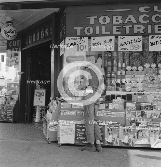 Half-grown farm boy on main drugstore corner in town, Medford, Oregon, 1939. Creator: Dorothea Lange.