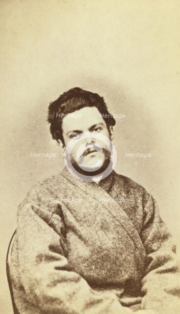 Half-length portrait of a man, dressed in convict clothing, facing front, between 1880 and 1886. Creator: Unknown.