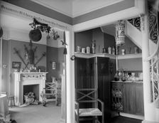 Hallway with liquor cabinet and living room decorated with mistletoe ball and Christm..., c1900-1915 Creator: Unknown