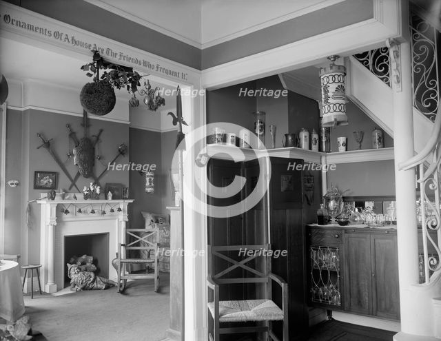 Hallway with liquor cabinet and living room decorated with mistletoe ball and Christm..., c1900-1915 Creator: Unknown.