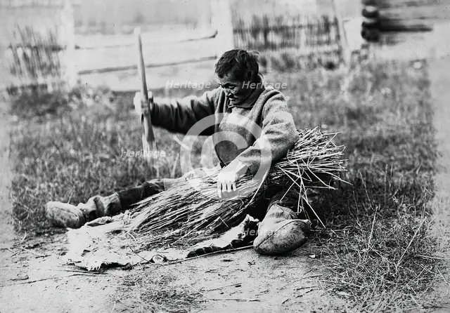 Hammering the sheaf, 1890.  Creator: Unknown.