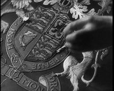 Hand of Seamstress Sewing a Royal Emblem, 1937. Creator: British Pathe Ltd