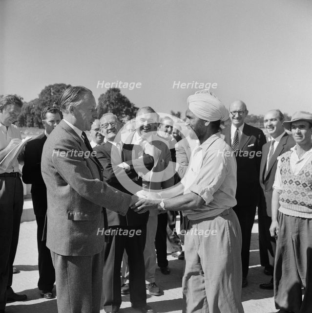 Harold Watkinson, shaking hands with labourer J. Singh, during a visit.., 07/09/1959. Creator: John Laing plc.