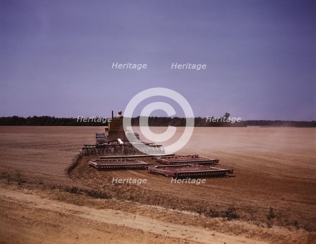 Harrowing a field with a diesel tractor, Seabrook Farm, Bridgeton, N.J., 1942. Creators: Marion Post Wolcott, John Collier.