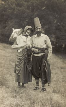 Harry Smallwood and another man stand in a field, one in drag and the other..., 1925. Creator: Unknown