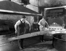 Heat treating a two metre saw blade, Slack Sellars & Co Ltd, Sheffield, South Yorkshire, 1963. Creator: Michael Walters