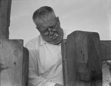 Henry Lotz closing the gate to the barns at the Midway City Dairy Association, near Santa Ana, 1937. Creator: Dorothea Lange