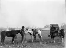 High Medicine Rock, Crow Indian with two horses at left, Her Horse Kills with child in..., c1908. Creator: Edward Sheriff Curtis