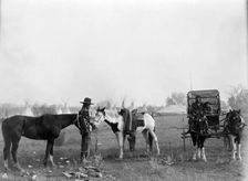 High Medicine Rock, Crow Indian with two horses at left, Her Horse Kills with child in..., c1908. Creator: Edward Sheriff Curtis