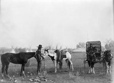 High Medicine Rock, Crow Indian with two horses at left, Her Horse Kills with child in..., c1908. Creator: Edward Sheriff Curtis