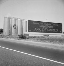 Highway gas tanks and signboard approaching town, between Tulare and Fresno on U.S. 99, 1939. Creator: Dorothea Lange