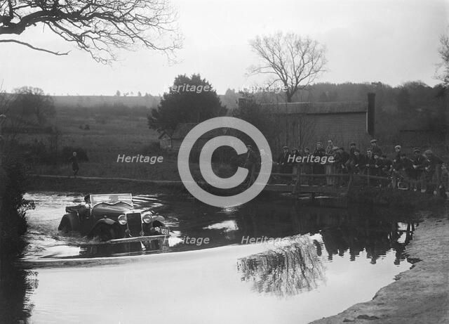 Hillman Aero Minx open 2-seater driving through a ford during a motoring trial, 1936. Artist: Bill Brunell.