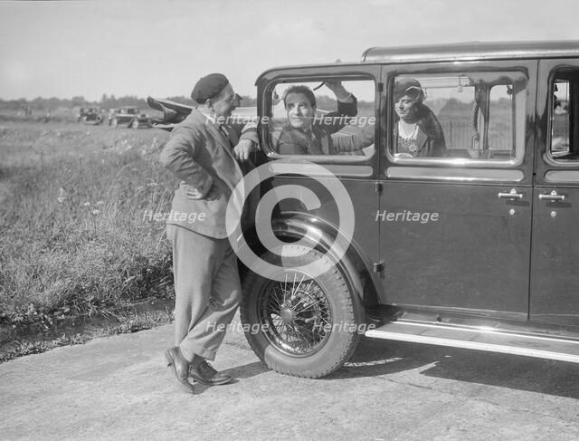 Hugh McConnell, Sammy Davis and Mrs Davis with an Austin 20/6 landaulette at Brooklands, 1931. Artist: Bill Brunell.