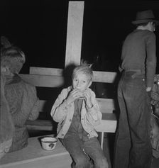 Hungry boy at the Halloween party for migrant workers, Shafter migrant camp, California, 1938. Creator: Dorothea Lange