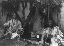In a Piegan lodge, c1910. Creator: Edward Sheriff Curtis