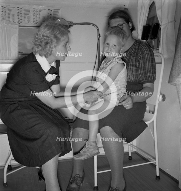 In trailer clinic, the nurse consults the migrant..., Merrill FSA camp, Klamath County, Oregon, 1939 Creator: Dorothea Lange.