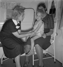 In trailer clinic, the nurse consults the migrant..., Merrill FSA camp, Klamath County, Oregon, 1939 Creator: Dorothea Lange