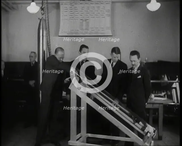 Interior Shot of a British Man Inserting Various Items in a Long Thin Glass Time Capsule..., 1938. Creator: British Pathe Ltd.