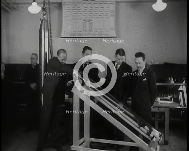 Interior Shot of a British Man Inserting Various Items in a Long Thin Glass Time Capsule..., 1938. Creator: British Pathe Ltd.