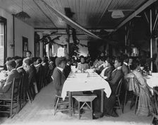 Interior view of dining hall, decorated for the holidays, with students... Tuskegee Institute, c1902 Creator: Frances Benjamin Johnston