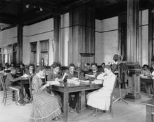Interior view of library reading room with male and female students... Tuskegee Institute, c1902. Creator: Frances Benjamin Johnston