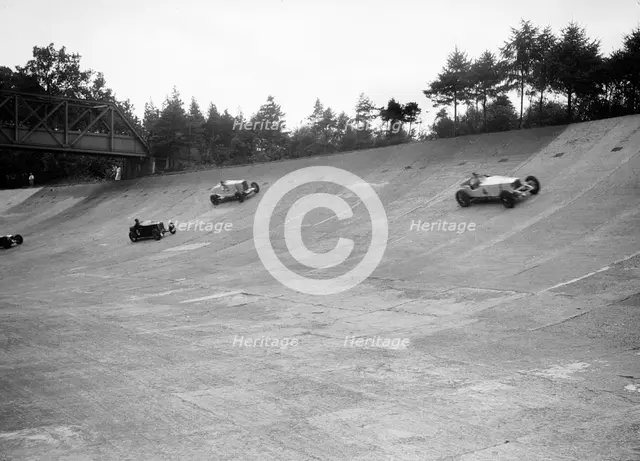 Invicta, Talbot and Frazer-Nash cars racing on the Members Banking at Brooklands. Artist: Bill Brunell.