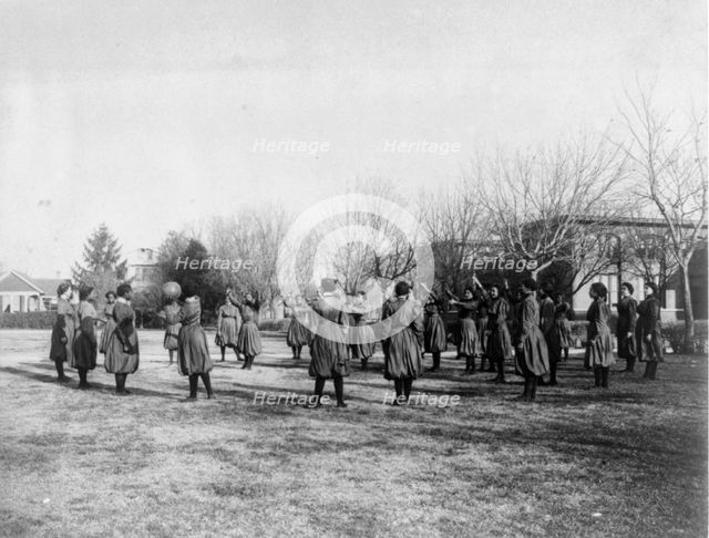 Indian and black girls exercising with medicine ball, Hampton Institute, 1899 or 1900. Creator: Frances Benjamin Johnston.