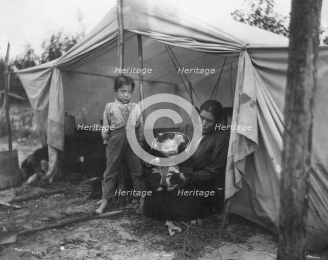 Indian children and mother at entrance of tent, between c1900 and 1927. Creator: Unknown.