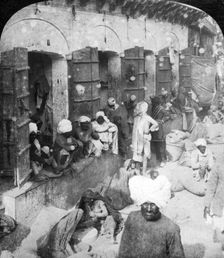 Indian women grinding corn between two round stones, Delhi, India, 1900s.Artist: Rose Stereographs